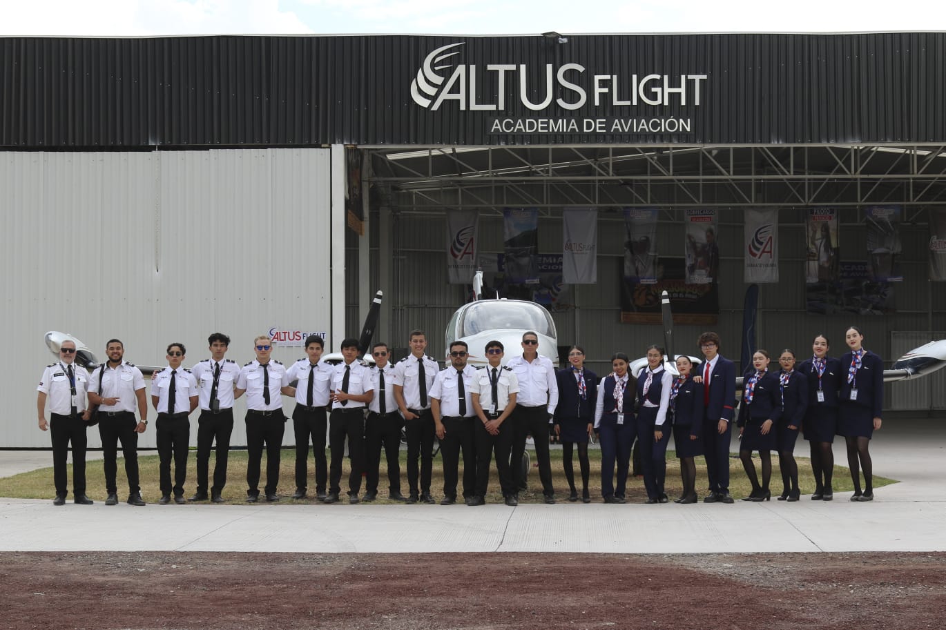 Pilotos y sobrecargos Altus Flight frente al hangar